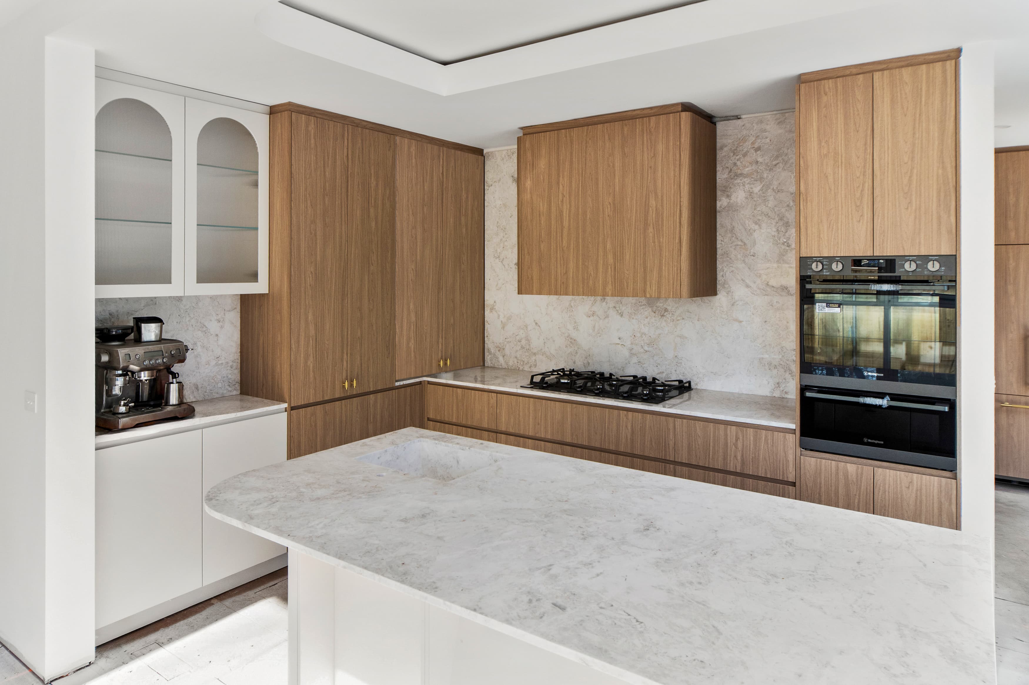 Completed kitchen with Chinese-sourced timber cabinetry and marble stone benchtops, Bembridge project
